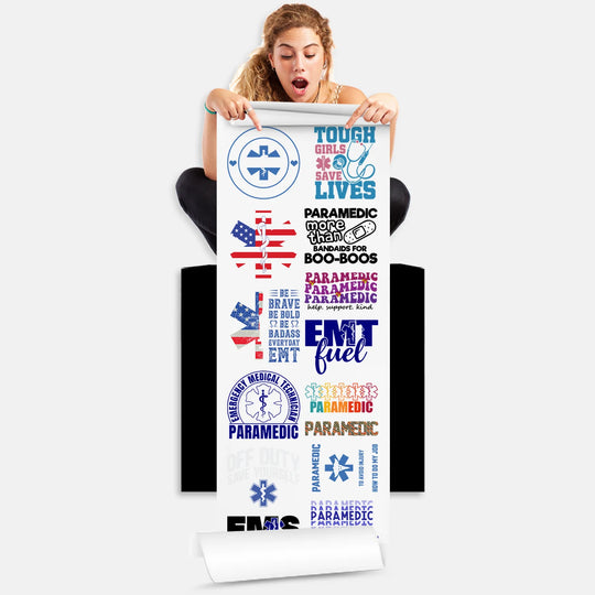 Woman holding EMT Paramedic DTF transfer gang sheet with 14 first responder designs ready to press