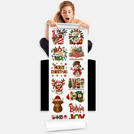 Person holding Yarn Christmas DTF Transfer gang sheet with 13 holiday designs featuring snowmen, reindeer, and festive text