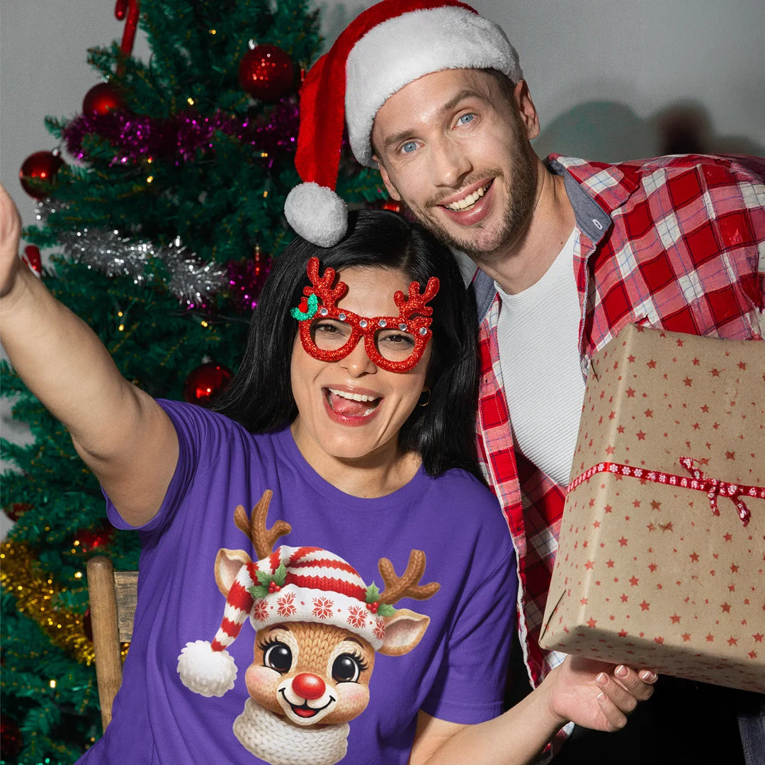 Person wearing Christmas t-shirt featuring cute reindeer DTF transfer design with festive Santa hat and holiday accessories