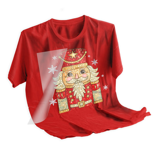 Heat press application of rhinestone nutcracker Christmas DTF transfer being applied to holiday shirt with professional equipment