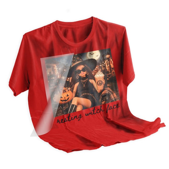 DTF transfer being heat pressed onto a black t-shirt showing the Resting Witch Face retro doll Halloween design application process using a heat press machine at 310 degrees Fahrenheit