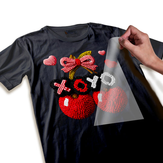 Close-up detail of Valentine cherry DTF transfer showing textured beaded surface quality and dimensional XOXO hearts design elements