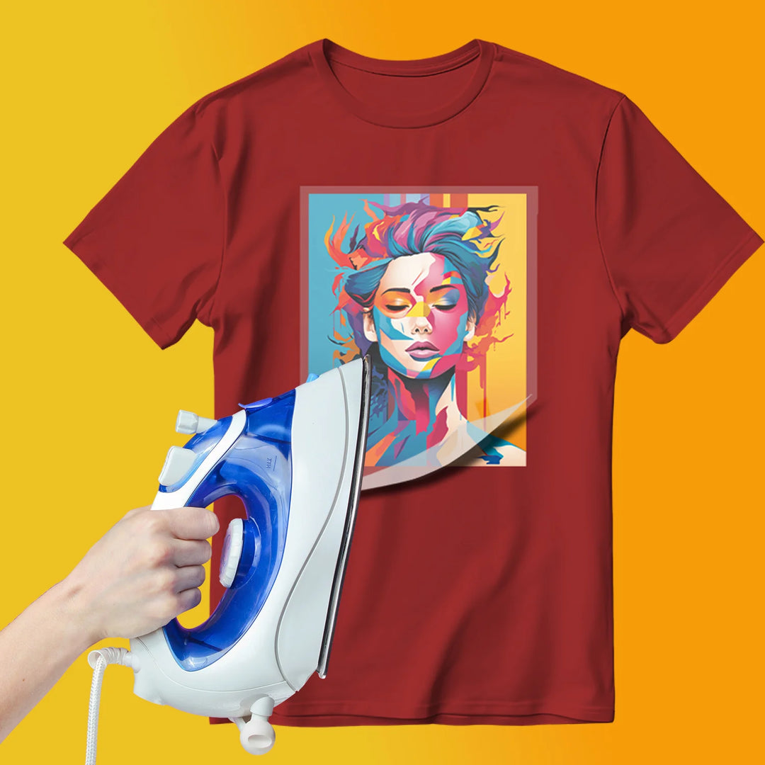 Hand holding a household iron applying a full colour DTF transfer to a red t-shirt showing carrier film being peeled back to reveal vibrant graphic design