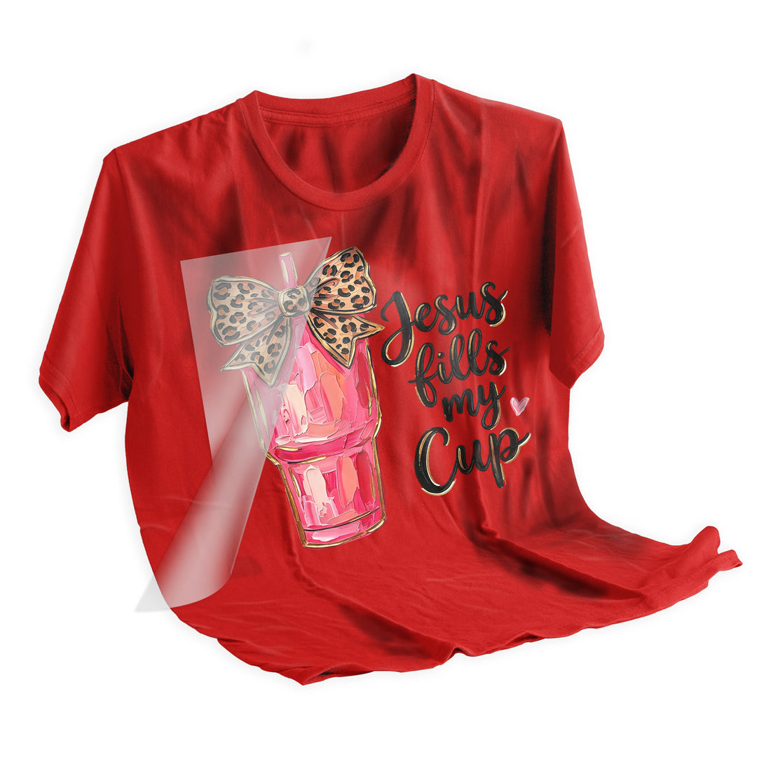 Heat press application of Jesus tumbler DTF transfer being applied to pink t-shirt with professional heat press machine