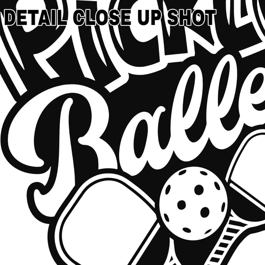 Pickleball DTF transfer design showing bold black text reading Pickle Baller with crossed paddles and ball graphic on transparent background
